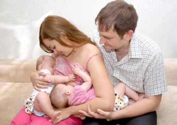 Rodzice podczas karmienia piersią dwóch dwieczynek 