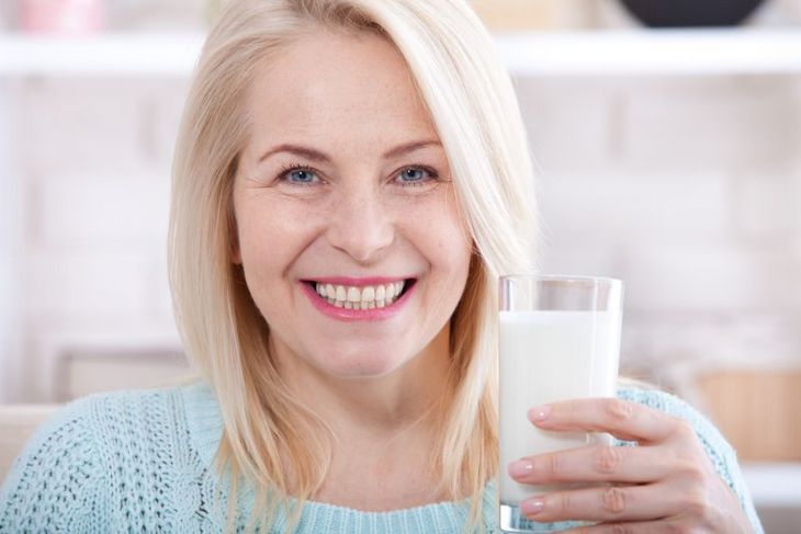 Kobieta w średnim wieku pijąca kefir
