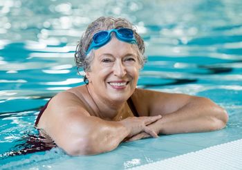 starsza kobieta pływa w basenie