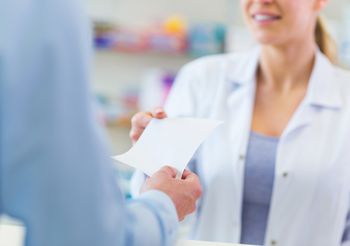 Pacjent podaje farmaceucie receptę. 