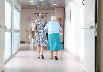 dwie kobiety idą szpitalnym korytarzem